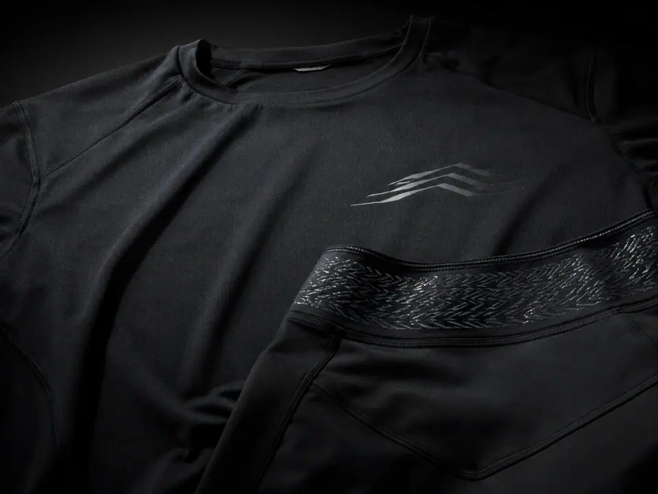Black athletic top with a tonal chest mark and a patterned silicone grip band