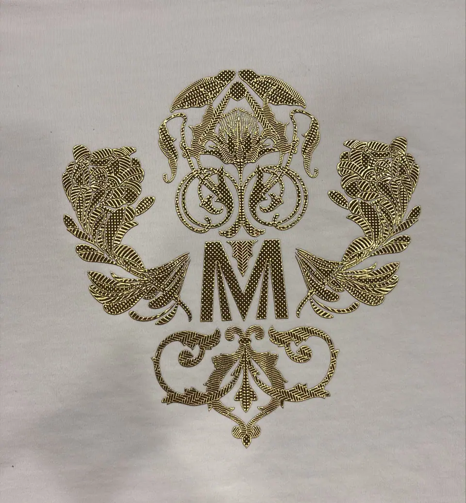 Metallic high-density monogram print with gold beadwork finish