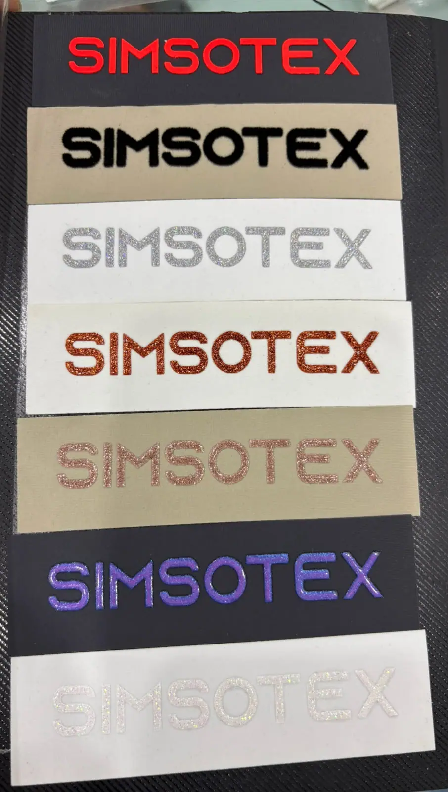 Stack of Simsotex woven labels in six colourways